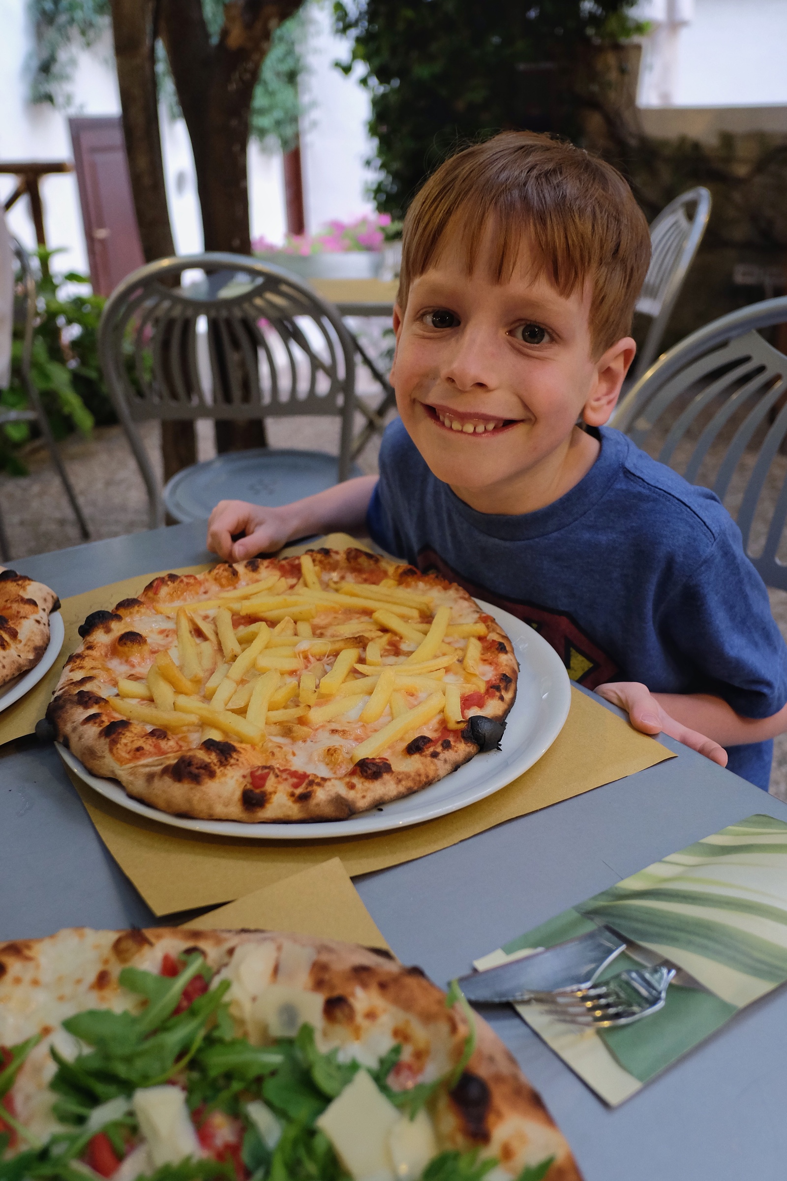 Rowan ordered a pizza with french fries on it. Do you think he's excited?